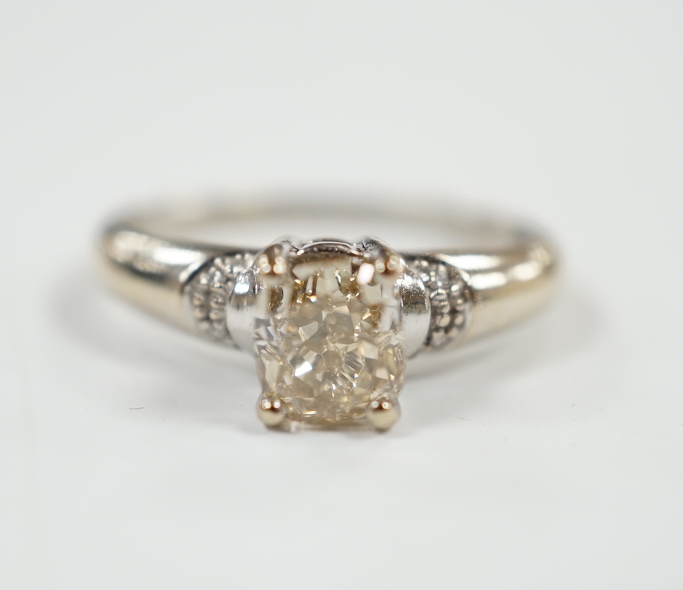 A 750 white metal and single stone oval cushion cut diamond ring, with four stone diamond chip set shoulders, size K, gross weight 3.3 grams.